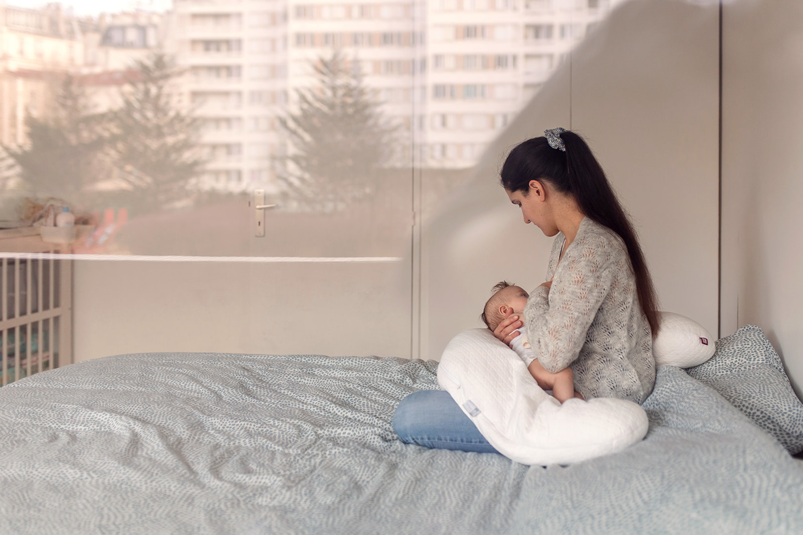 mother breastfeeding her baby, seen through a window