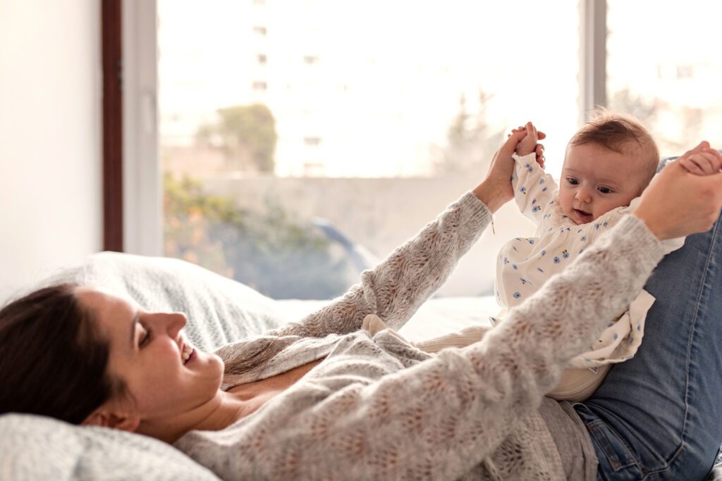 a mom is playing with her baby during a photo session