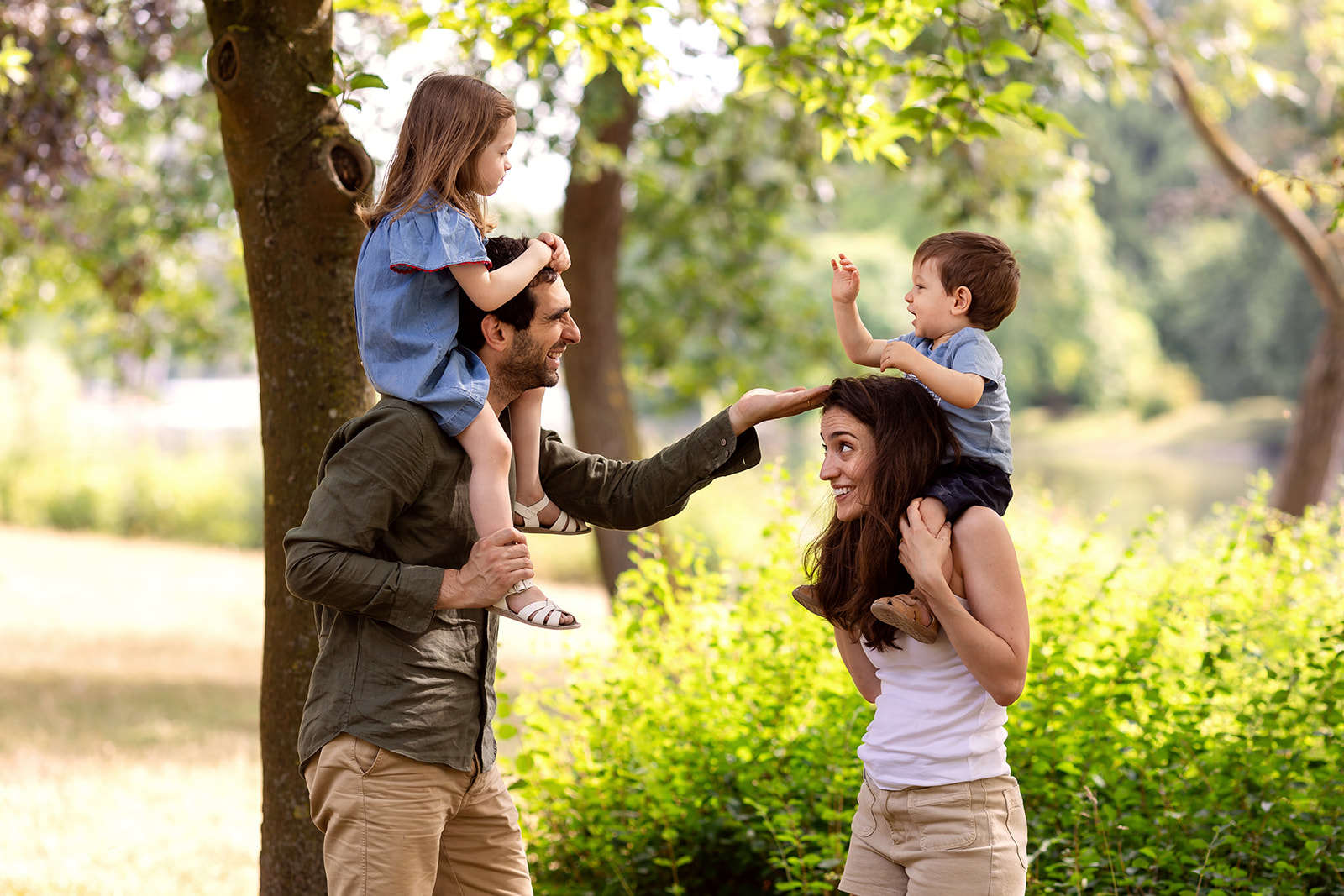 outdoor photo session with a family of 4. Parents hold their kids and play