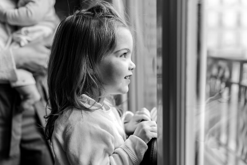 a little girl looking out the window and smiling