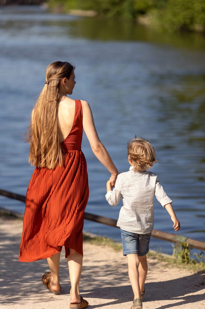 Outdoor photo session of a mother and her little boy near a lake