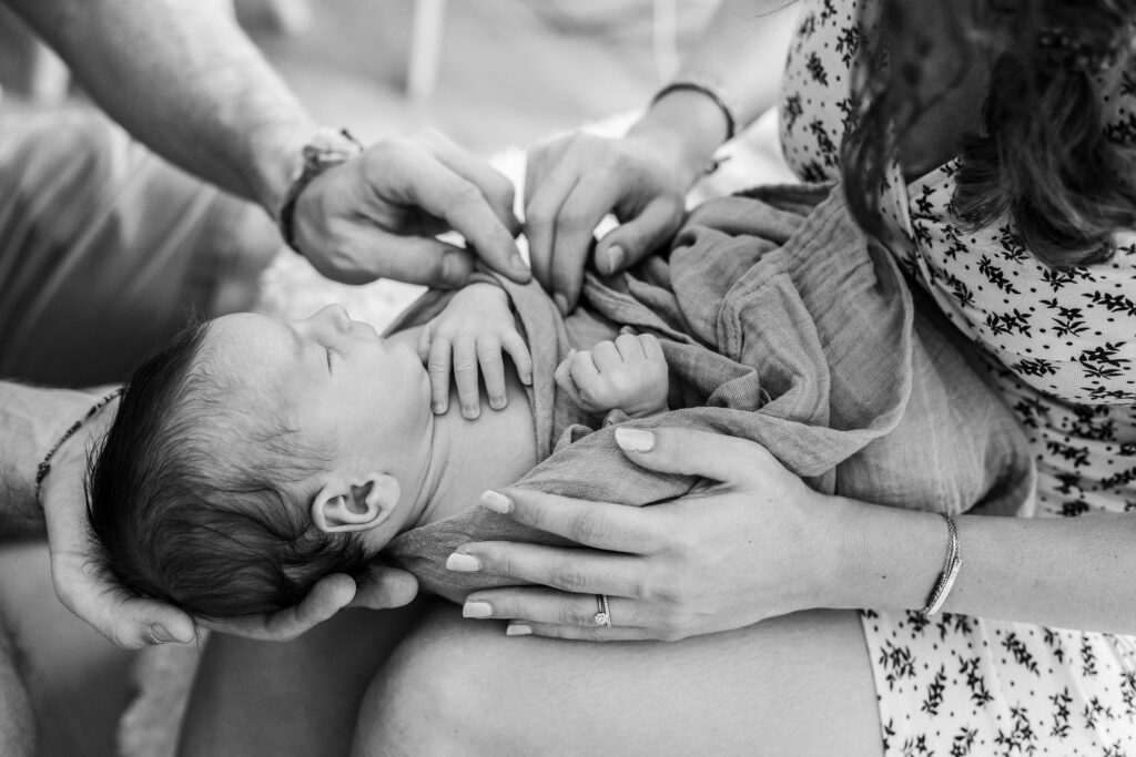a mother hold her newborn during a professional photo session, Gift ideas for parents of a newborn