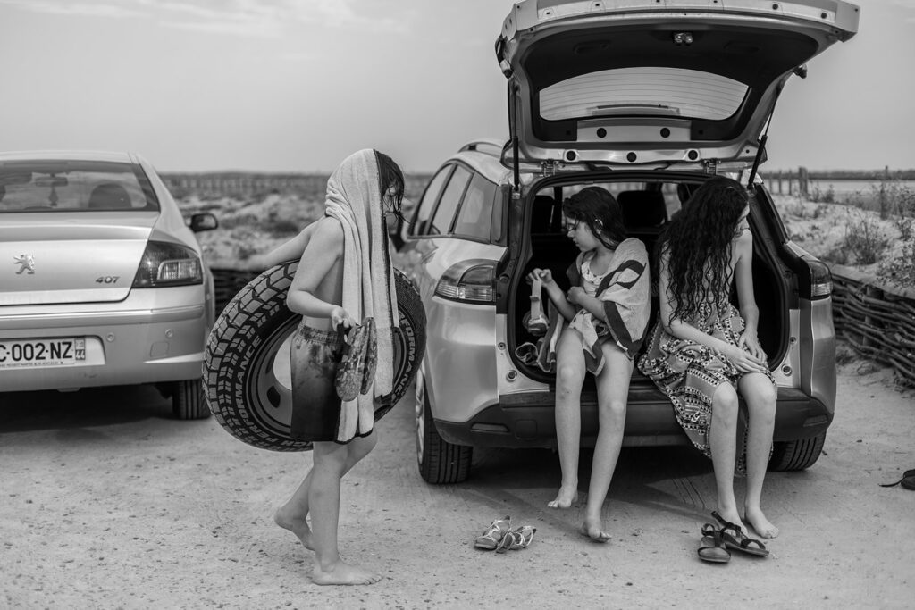 Three children getting ready to leave the beach after a family day out