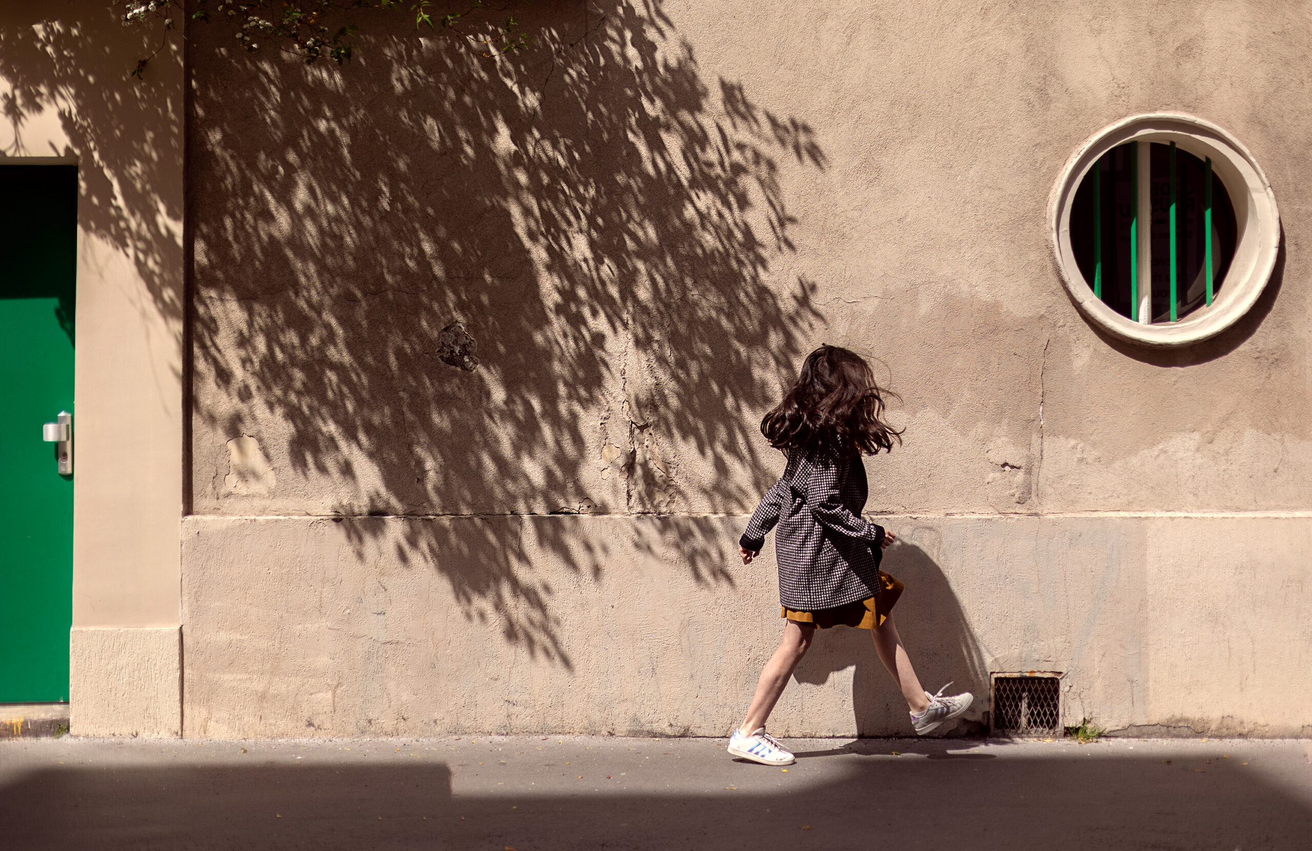 Girl walking along a sunlit street