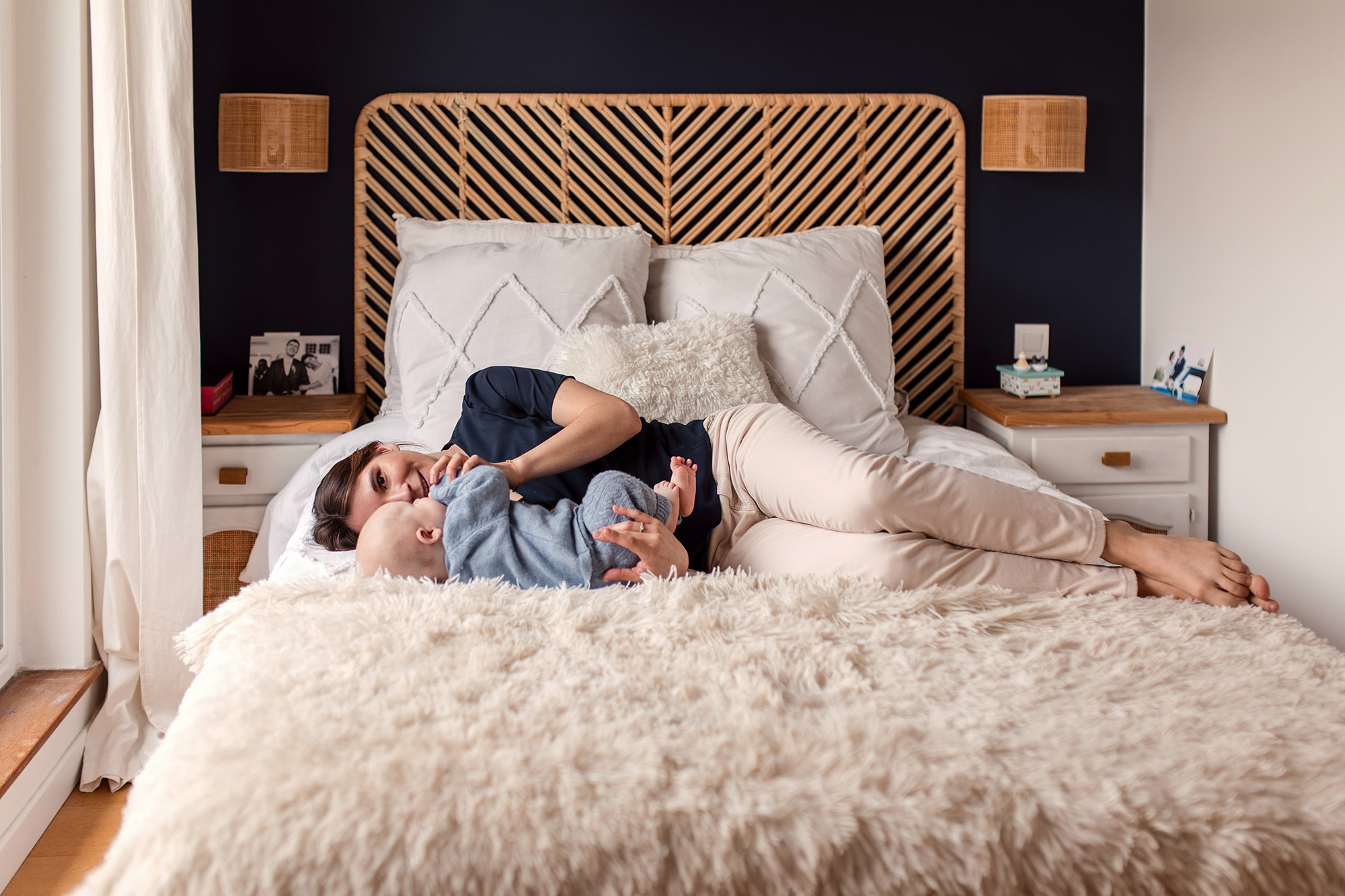 Mother holding her baby on the bed during an at-home family session