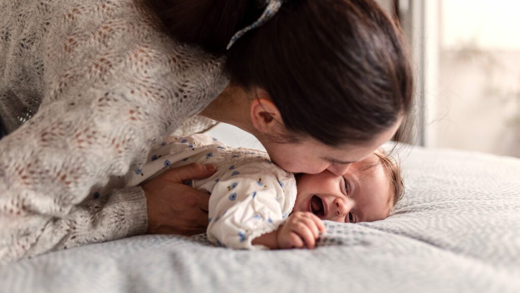 a mother kissing her baby