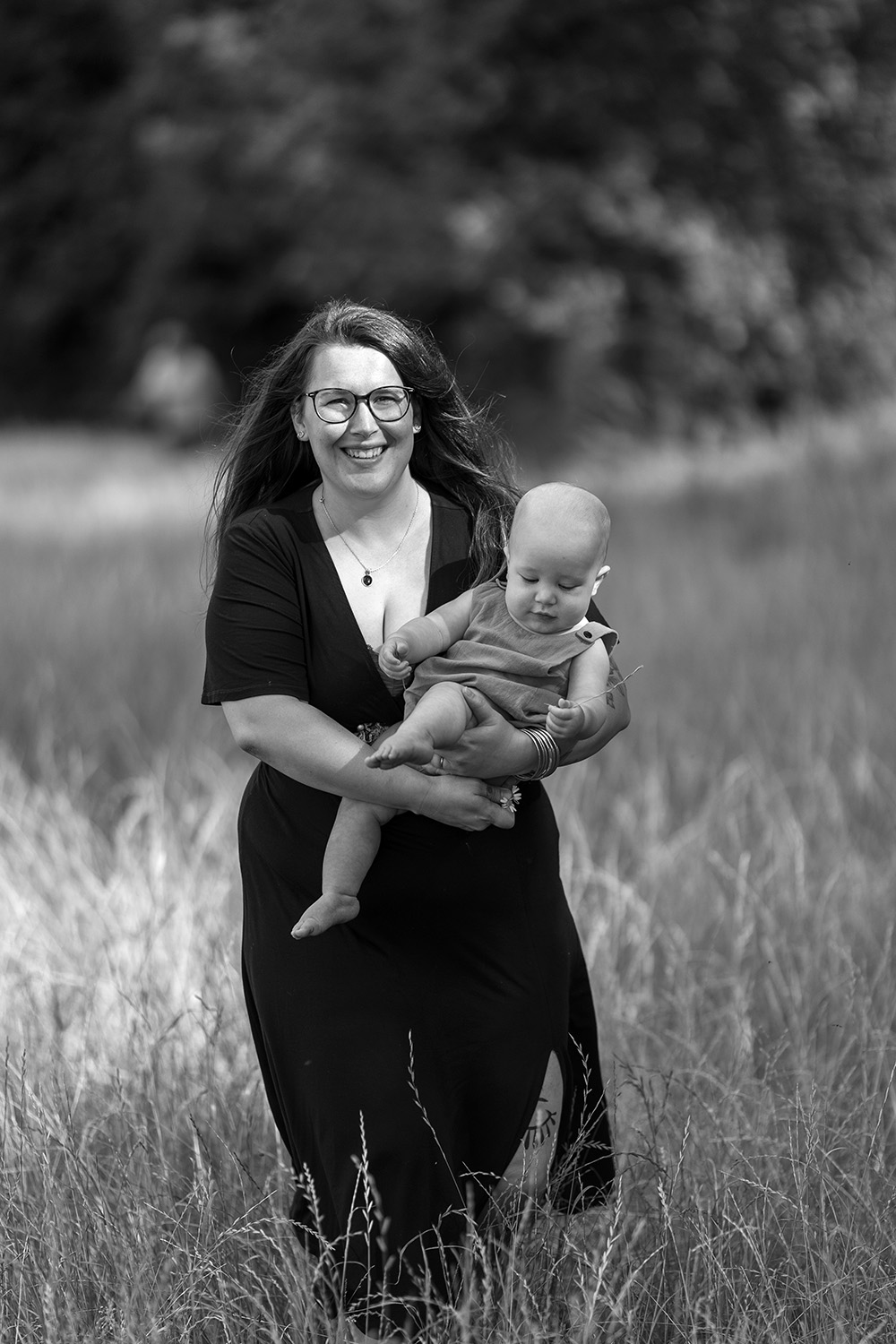 a mother holds her baby and walks in the park, to show and exemple of What to wear for a photo session