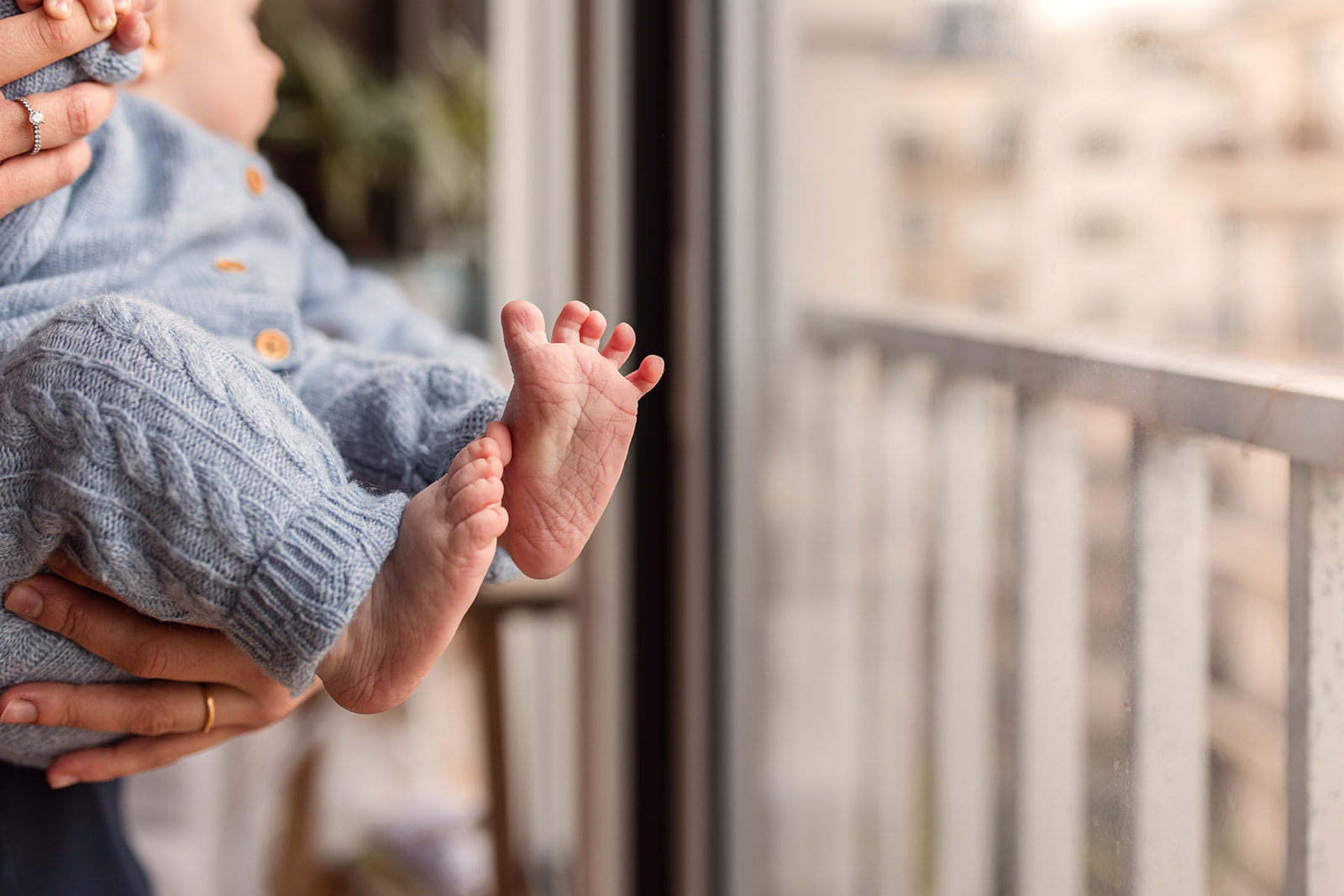 Tiny newborn feet resting in soft window light at home