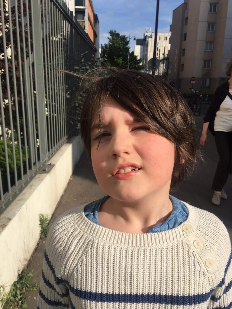 Child photographed in harsh direct sunlight on a city street
