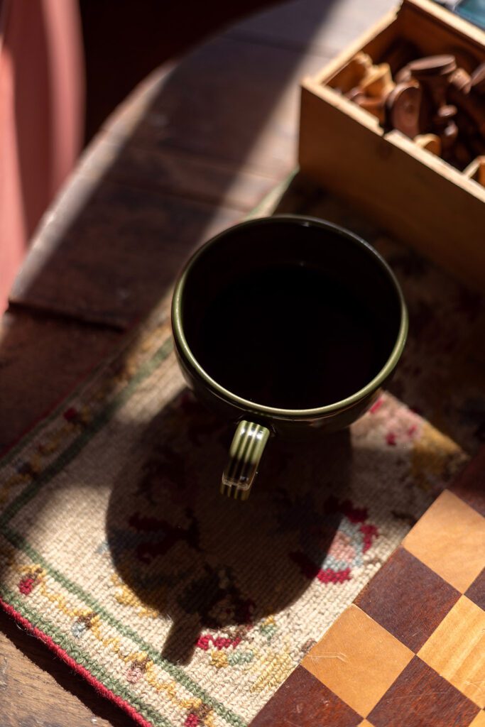 Cup of coffee casting a shadow in warm morning light