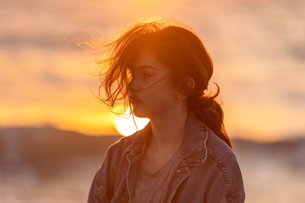 Girl photographed in warm sunset light by the sea