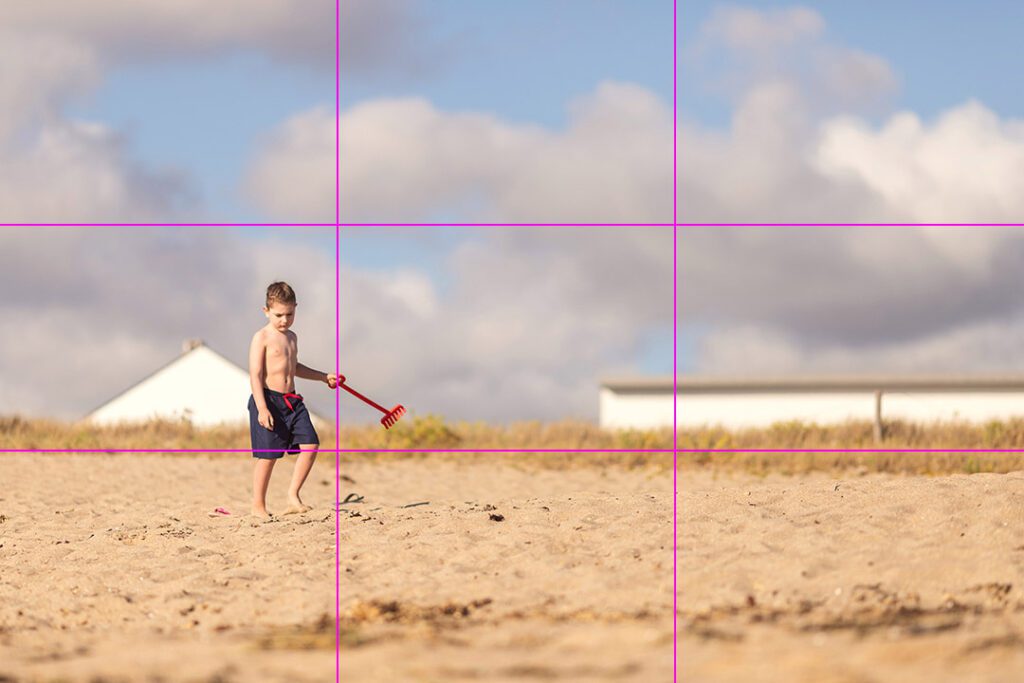 Child on a beach with a rule-of-thirds grid overlay