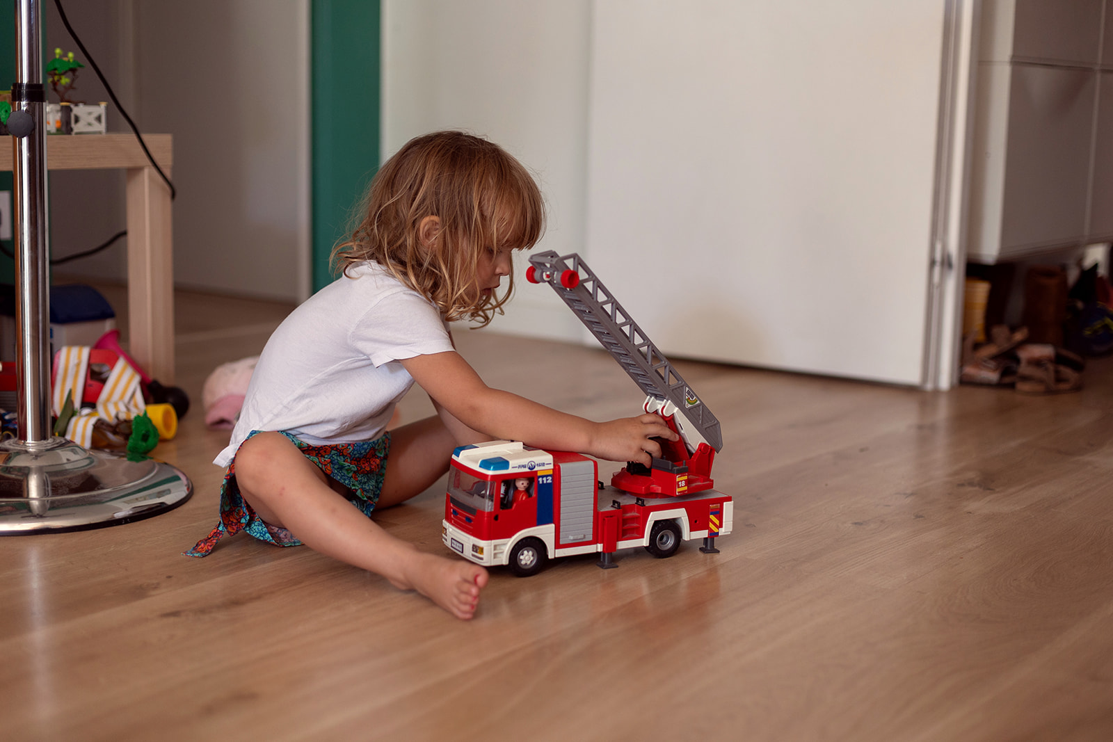 little girl playing with a truck toy