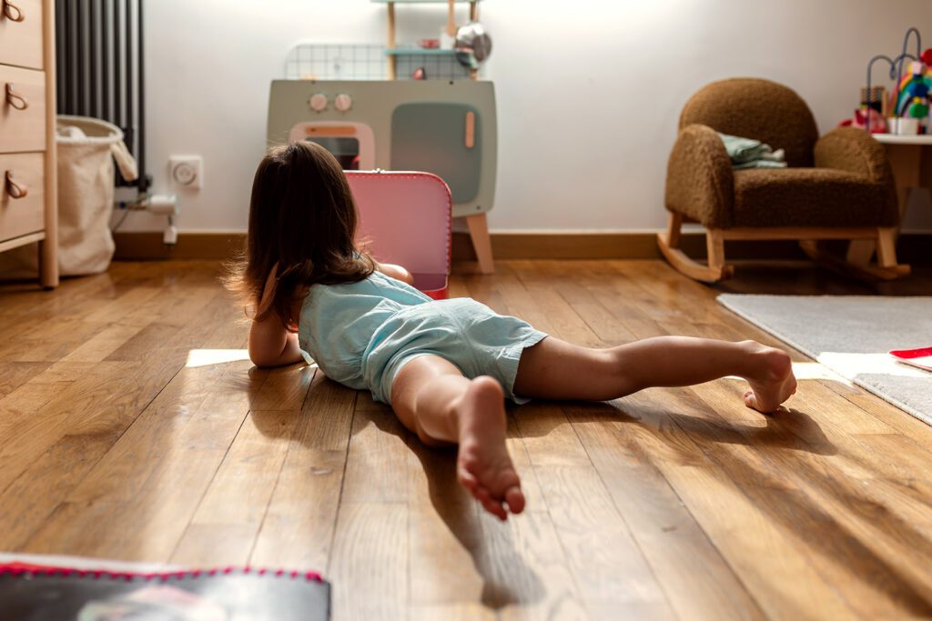 a little girl playing on the floor in her room