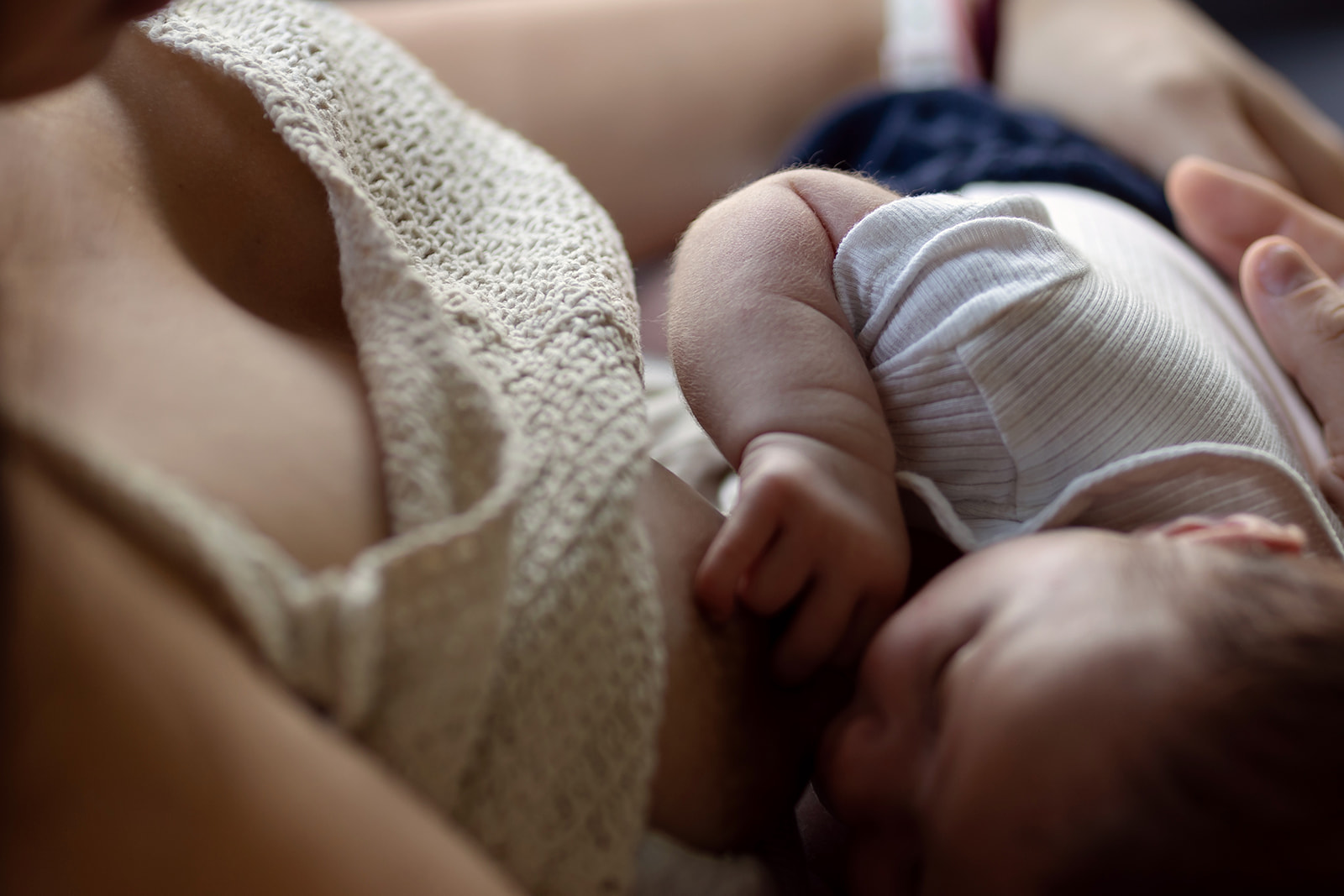 a mother breastfeeding her newborn in her home