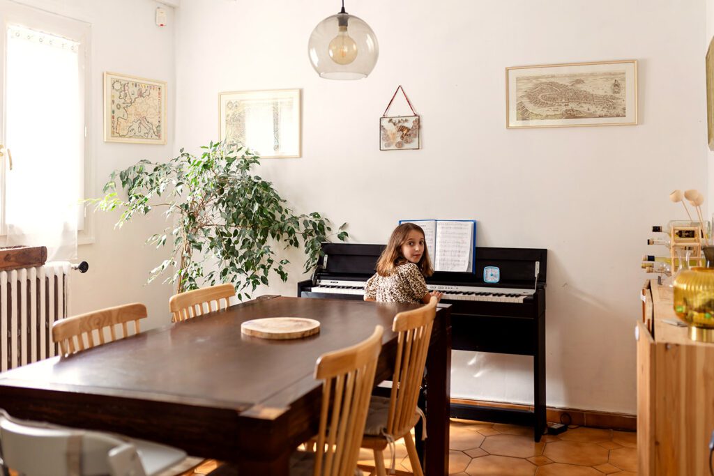 little girl playing the piano in her home during a Family photography session