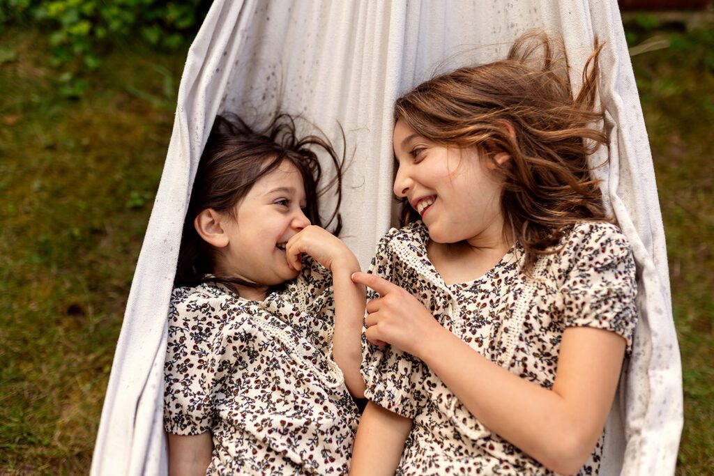 little girls laughing in a hammoc during a day in the life session