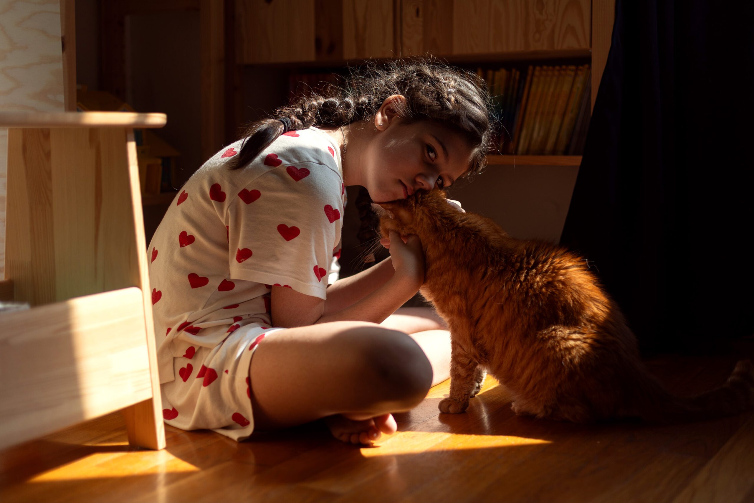 little girl cuddling her cat at home. photo illustrationg why childhood photos matter