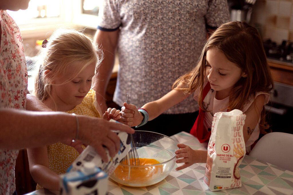 two little girls cooking with their grandparents