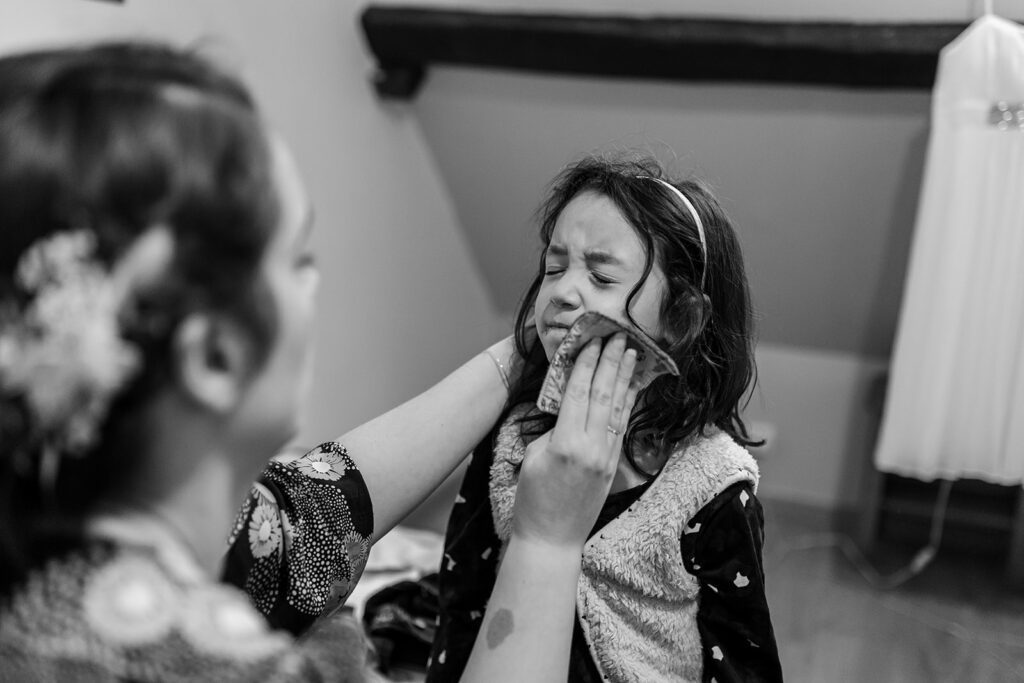 a mom is cleaning her child's face after a snack