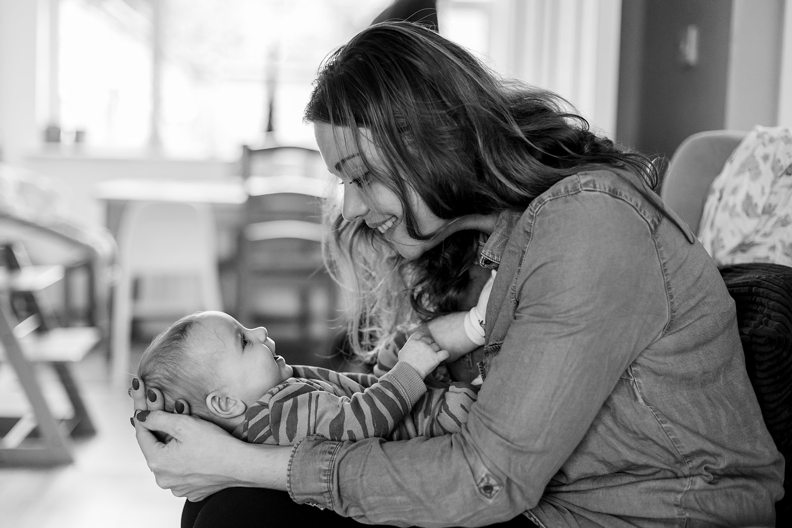 a mother holding her baby, smiling