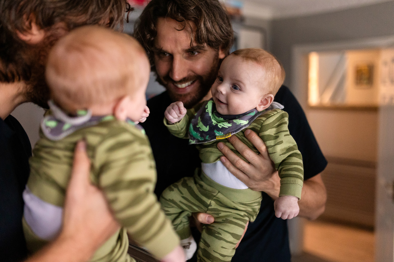 a father showing his baby his reflection in the mirror, smiling