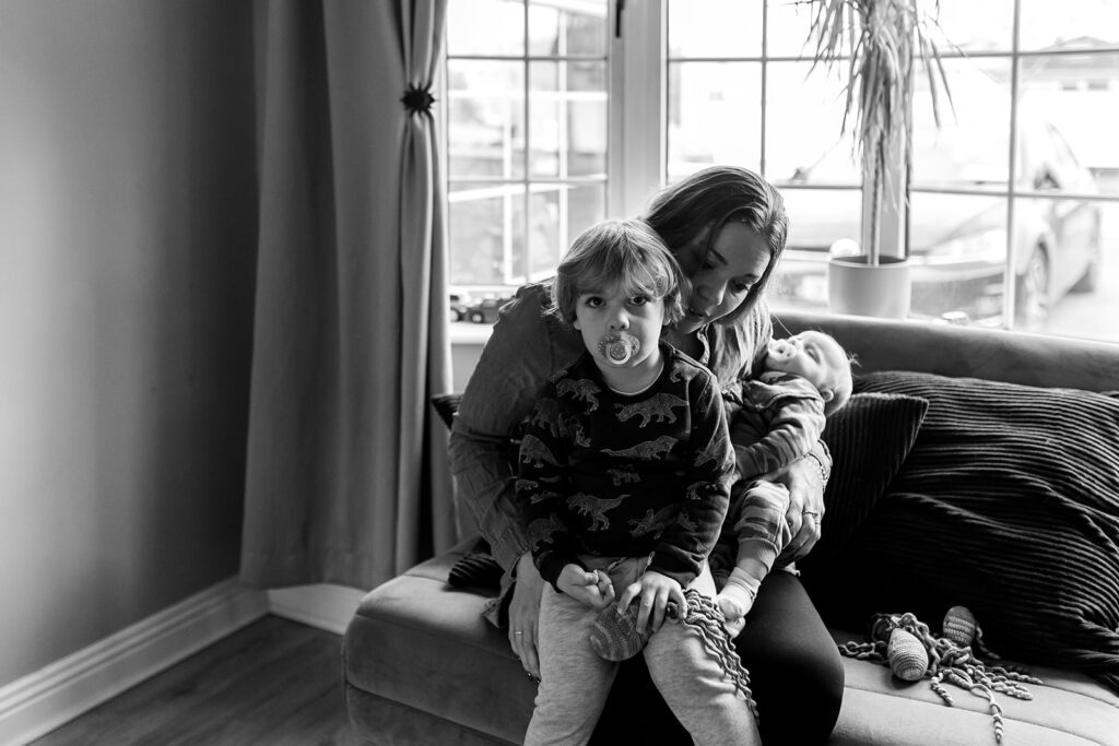 mother and her 2 kids sitting by the window at home