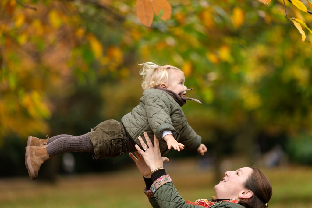 a mother playing with her toddler at the park