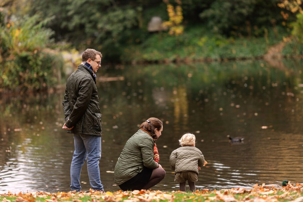 father, mother and child by the lake in st stephen's green park