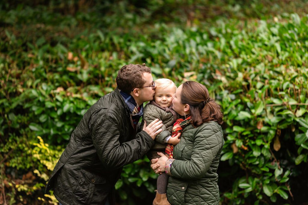 parents kissing their toddler girl