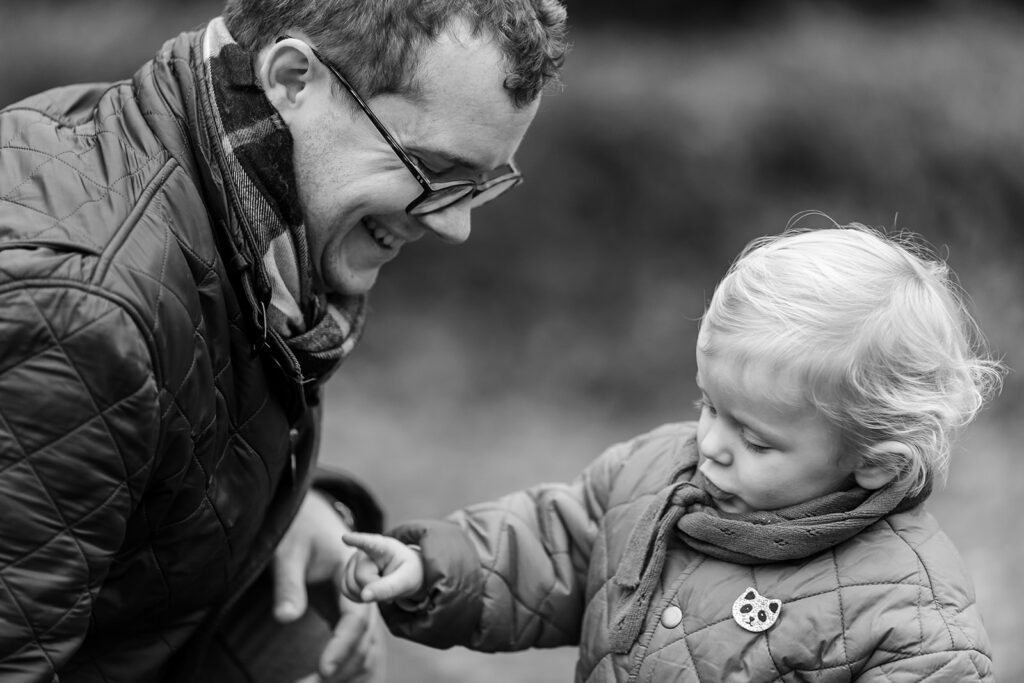 father giving a flower to his toddler at the park