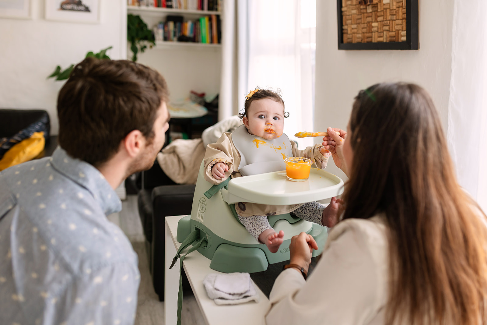 documentary family portraits of parents spoon feeding their baby