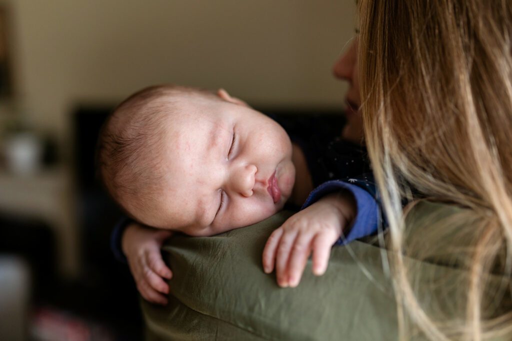 newborn baby sleeping in her mother's arms