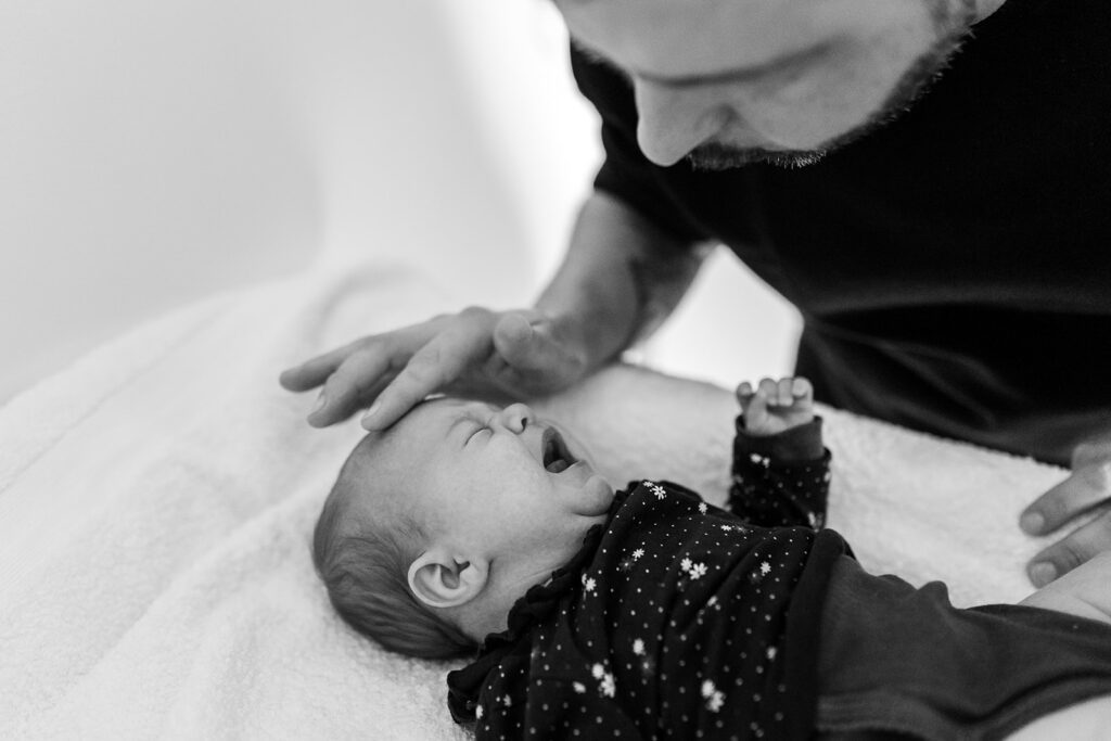 father comforting his crying newborn