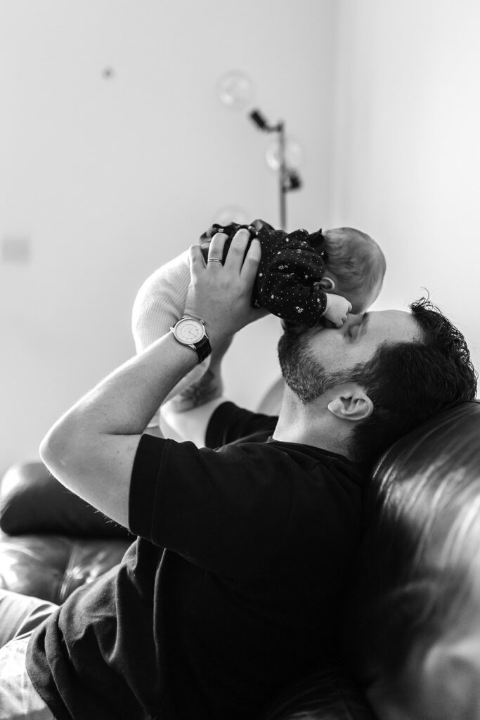 dad playing with newborn