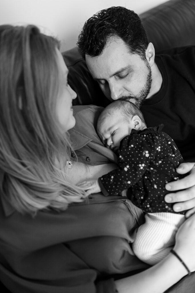 father kissing his newborn during a Professional newborn photography session in Dublin