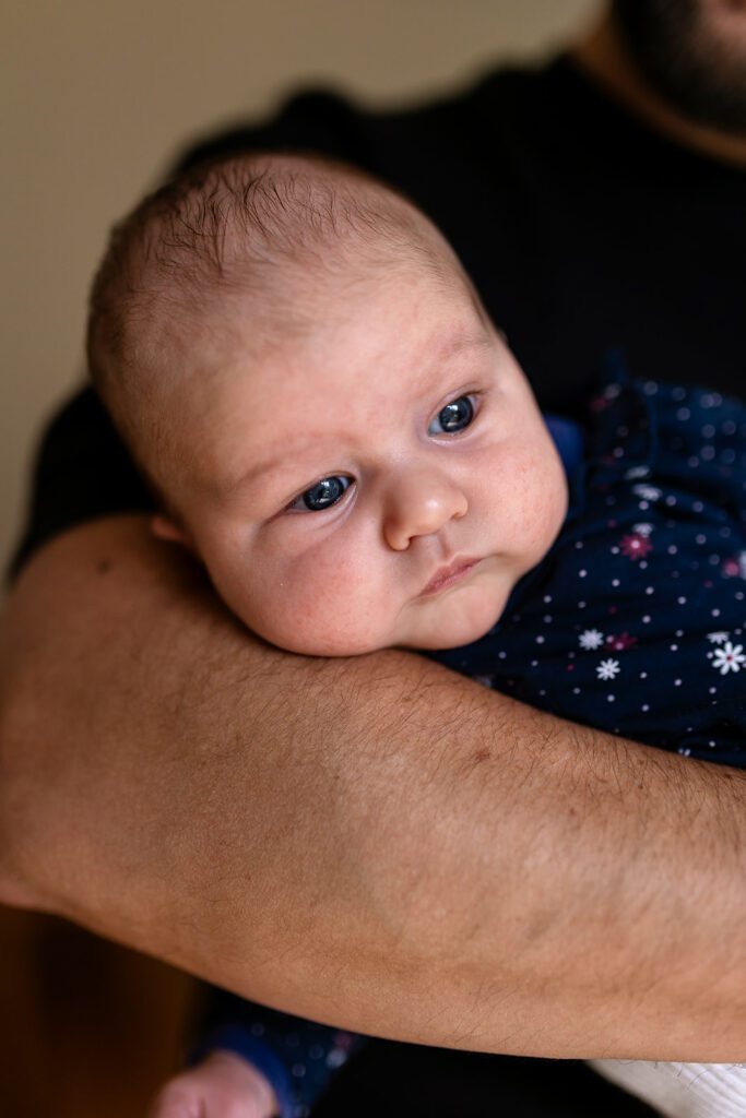 a newborn in her father's arms What to expect during a Dublin family photo session