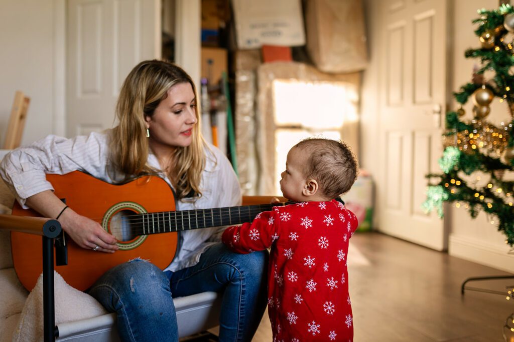 mother playing guitar for her baby