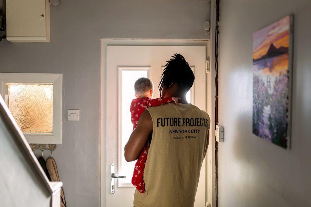 father and baby in their home with soft winter light