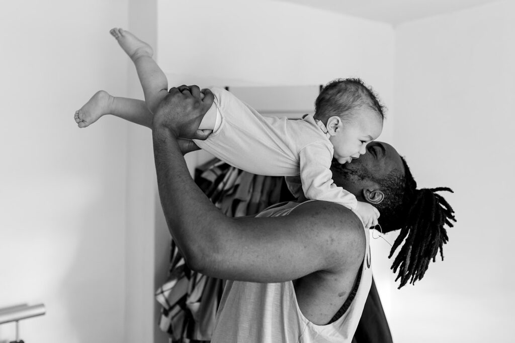 father holding his baby up in the air