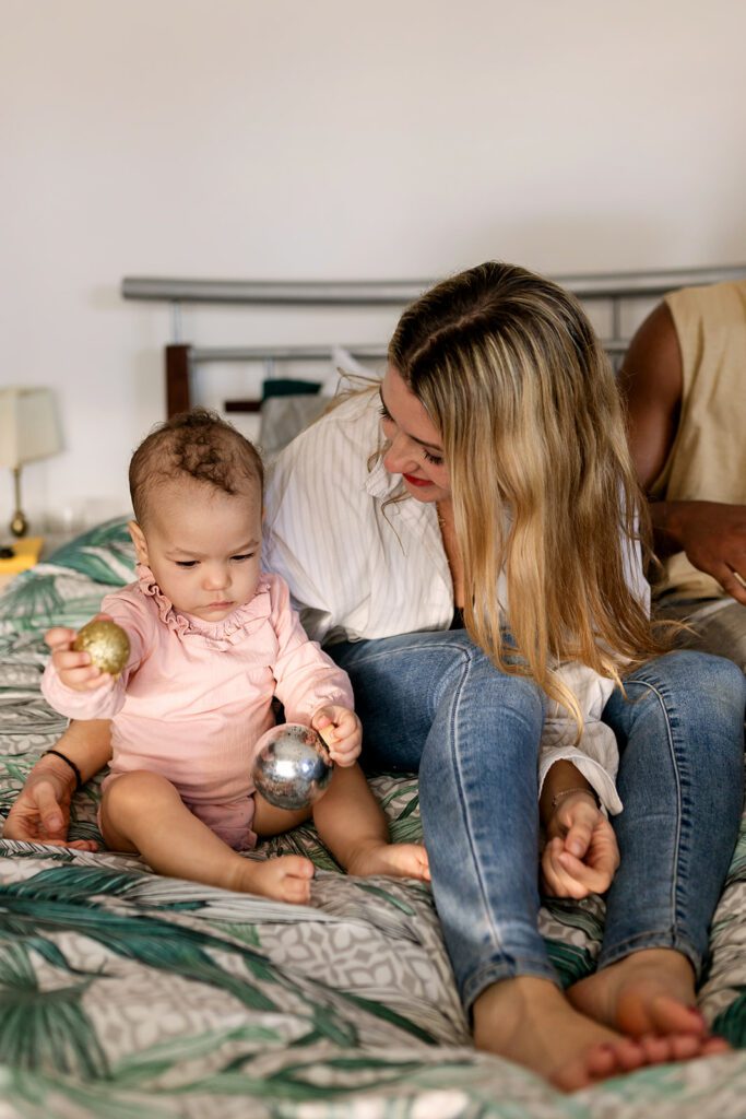 mother and baby playing on the bed during a Family session before moving