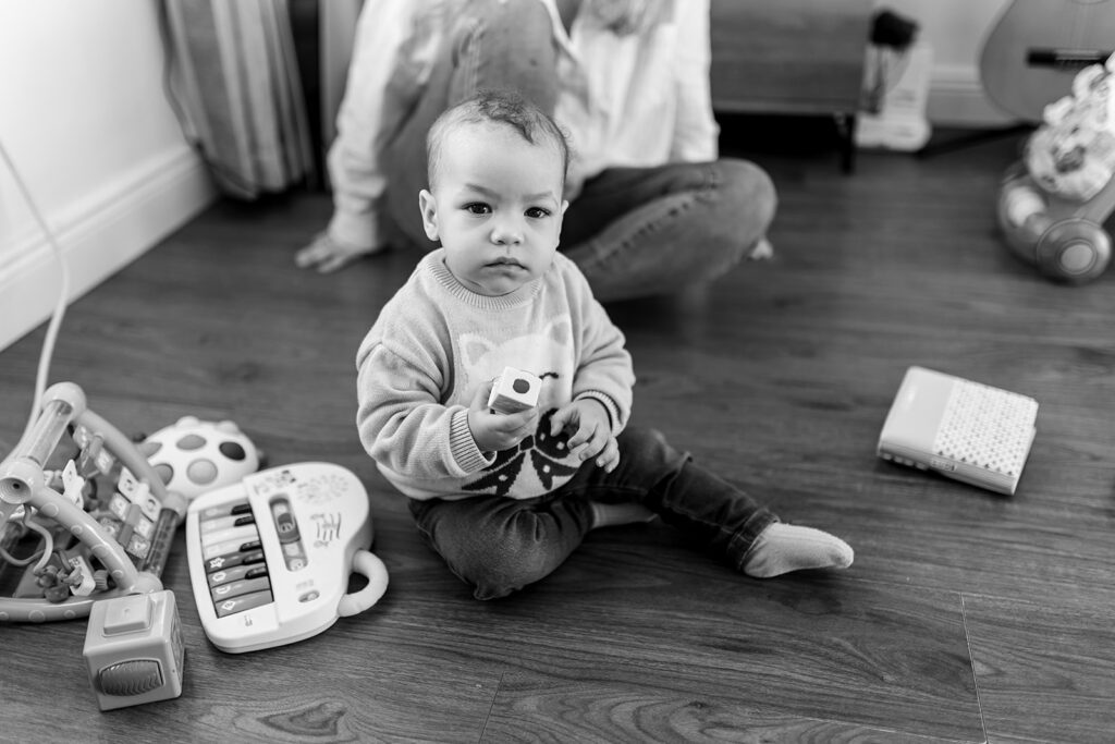 baby playing with toys in her home, sitting on the floor