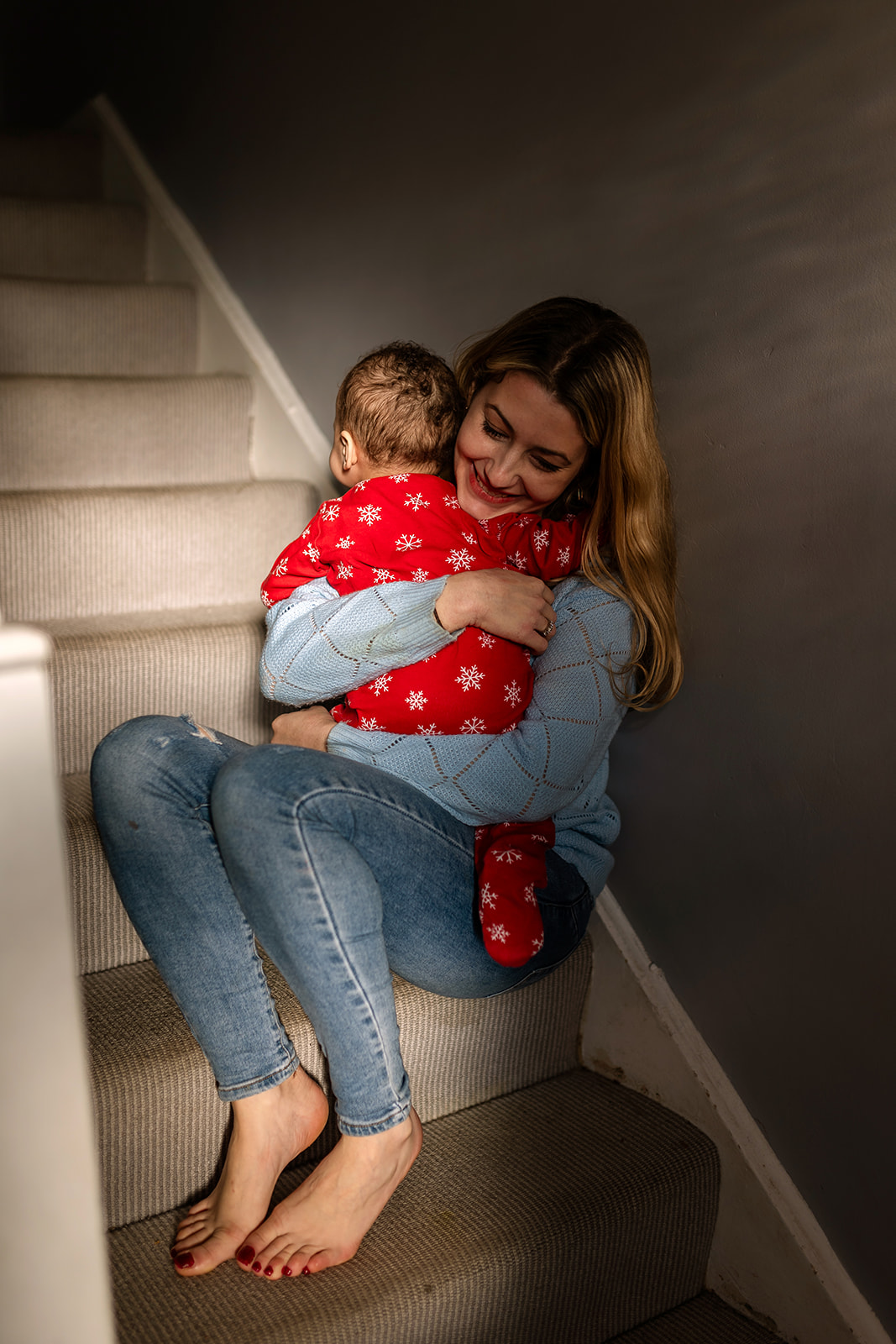 mother and baby sitting on their home stairs, during a Family session before moving