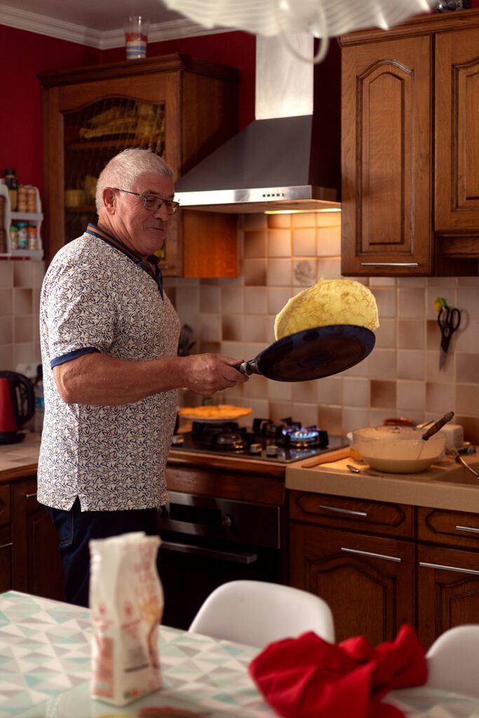 grandfather making crepes at home for his family