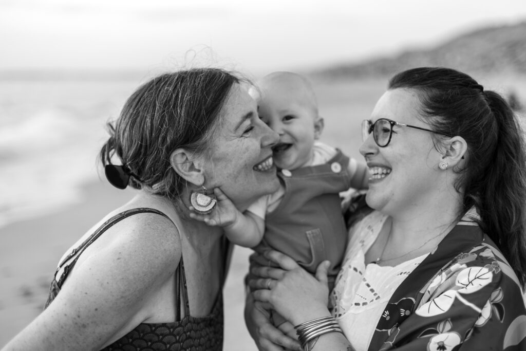 daughter, grandmother and baby smiling at each other