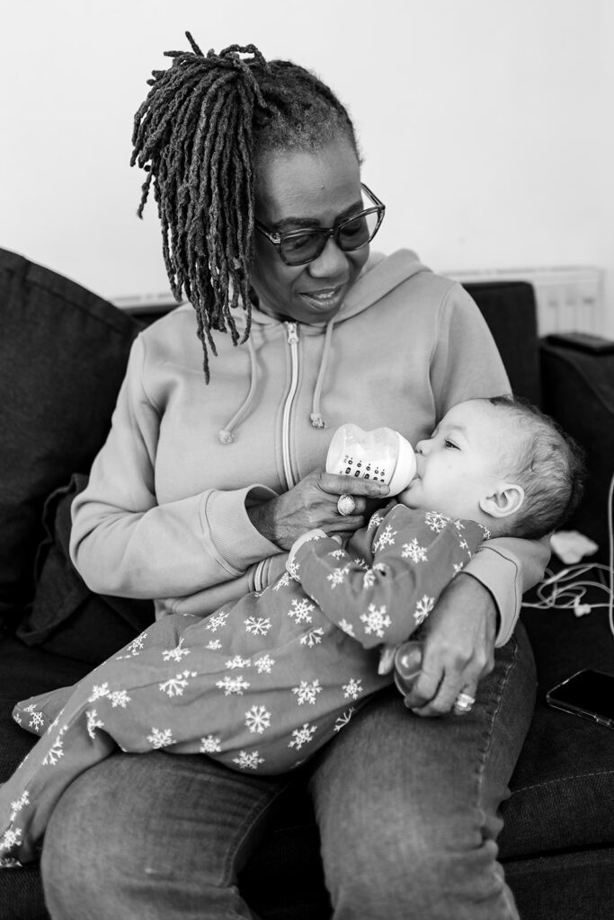 grandmother feeding a bottle to her granddaughter