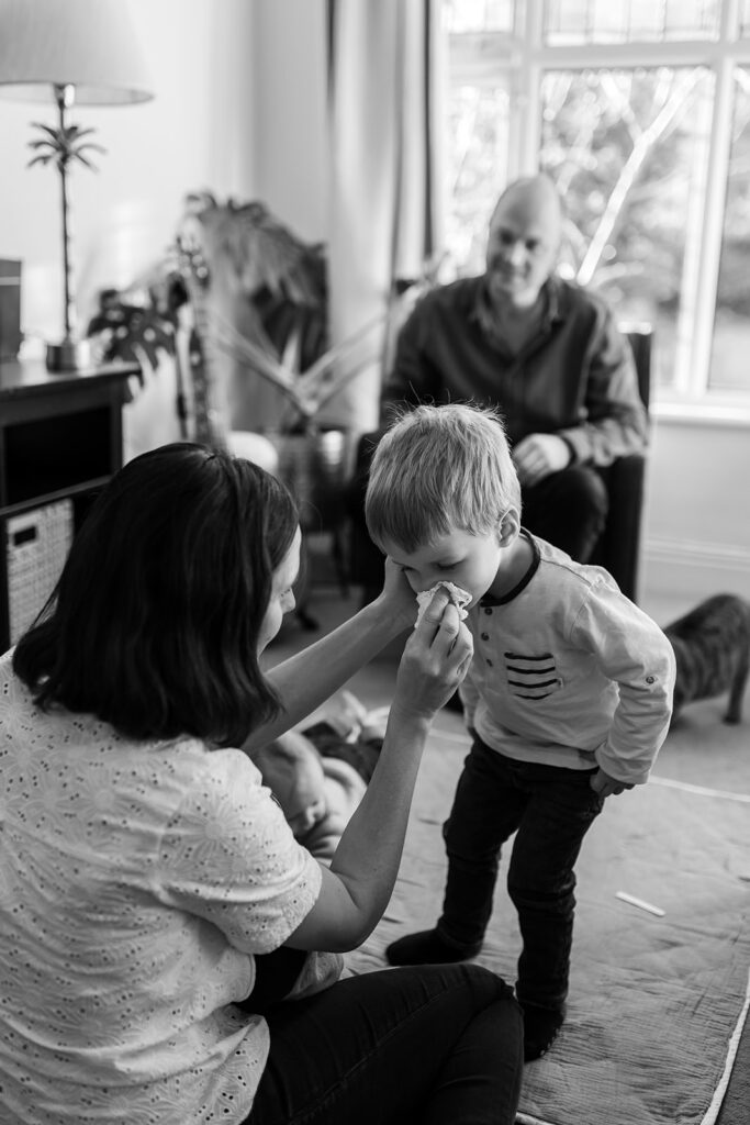 mum taking care of her toddler during a In home twin baby photos with sibling