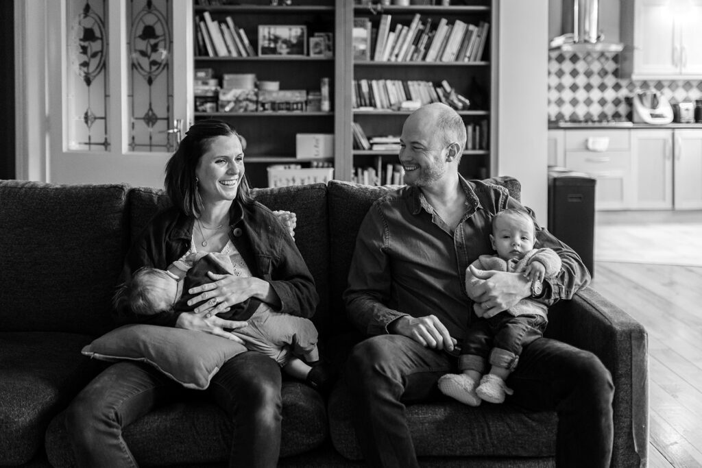 family sitting on their couch with baby twins