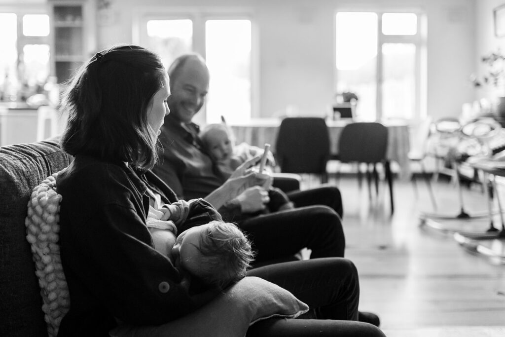 unposed newborn photography, parents taking care of newborns at home