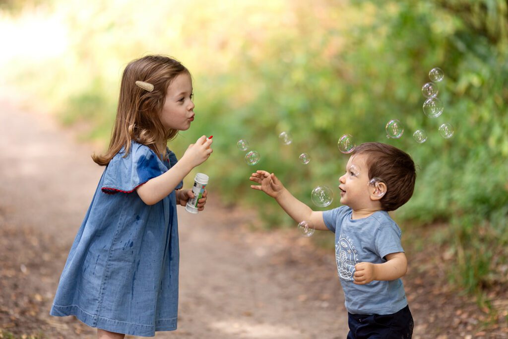 kids blowing bubbles at the park